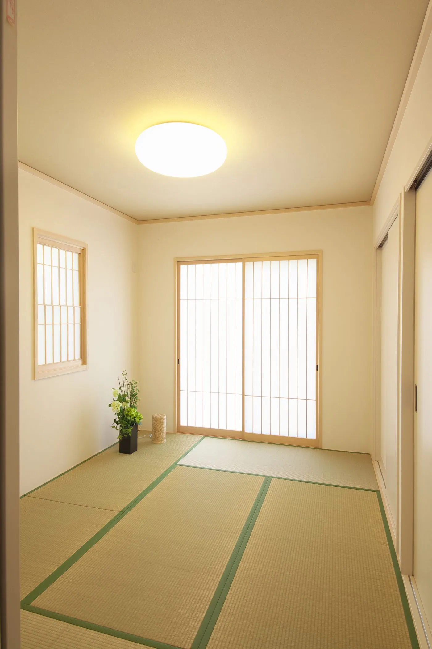 畳が敷かれ、障子の引き戸と天井の照明がある和室