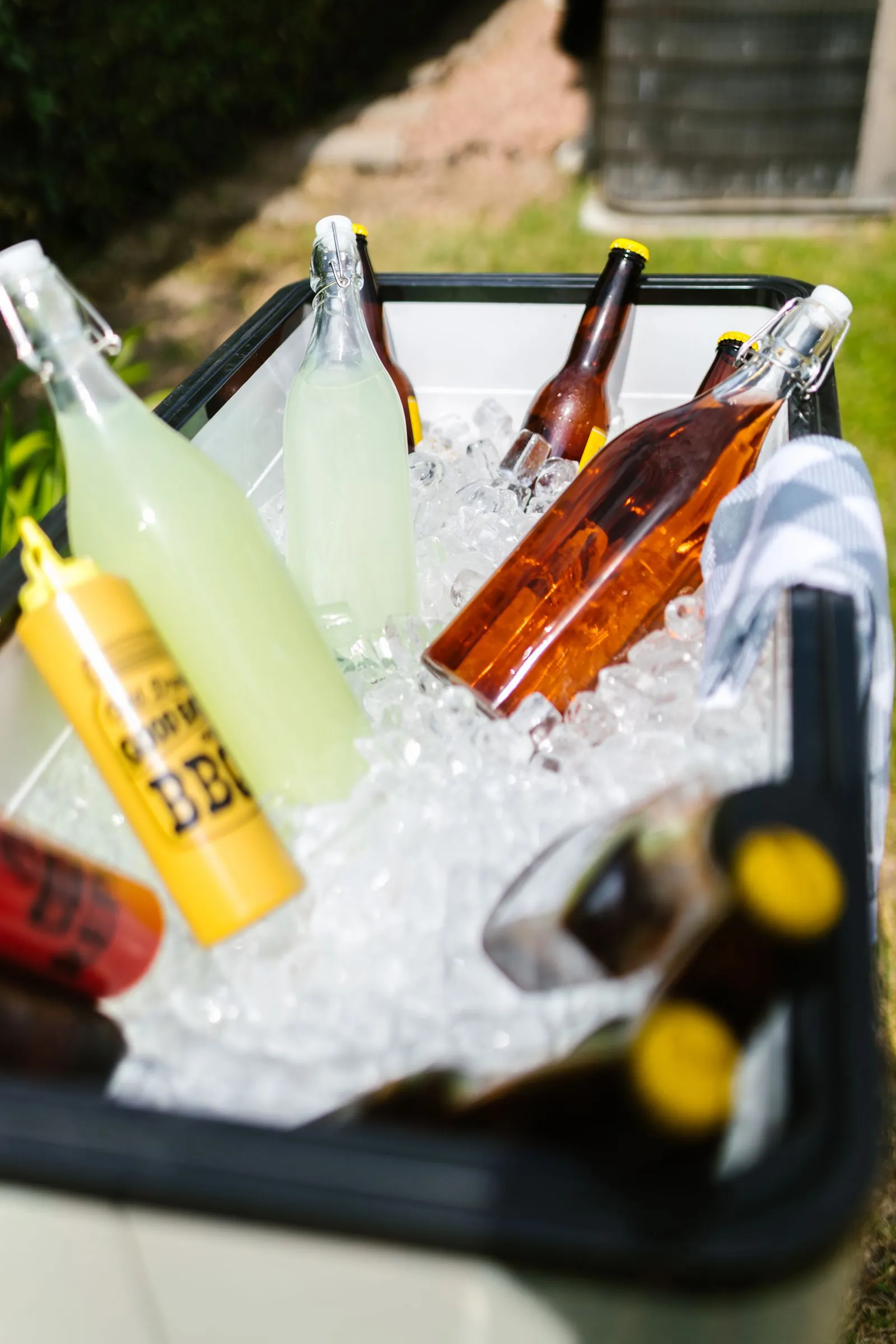 氷を入れた黒いクーラーボックスに並ぶ飲み物のボトル