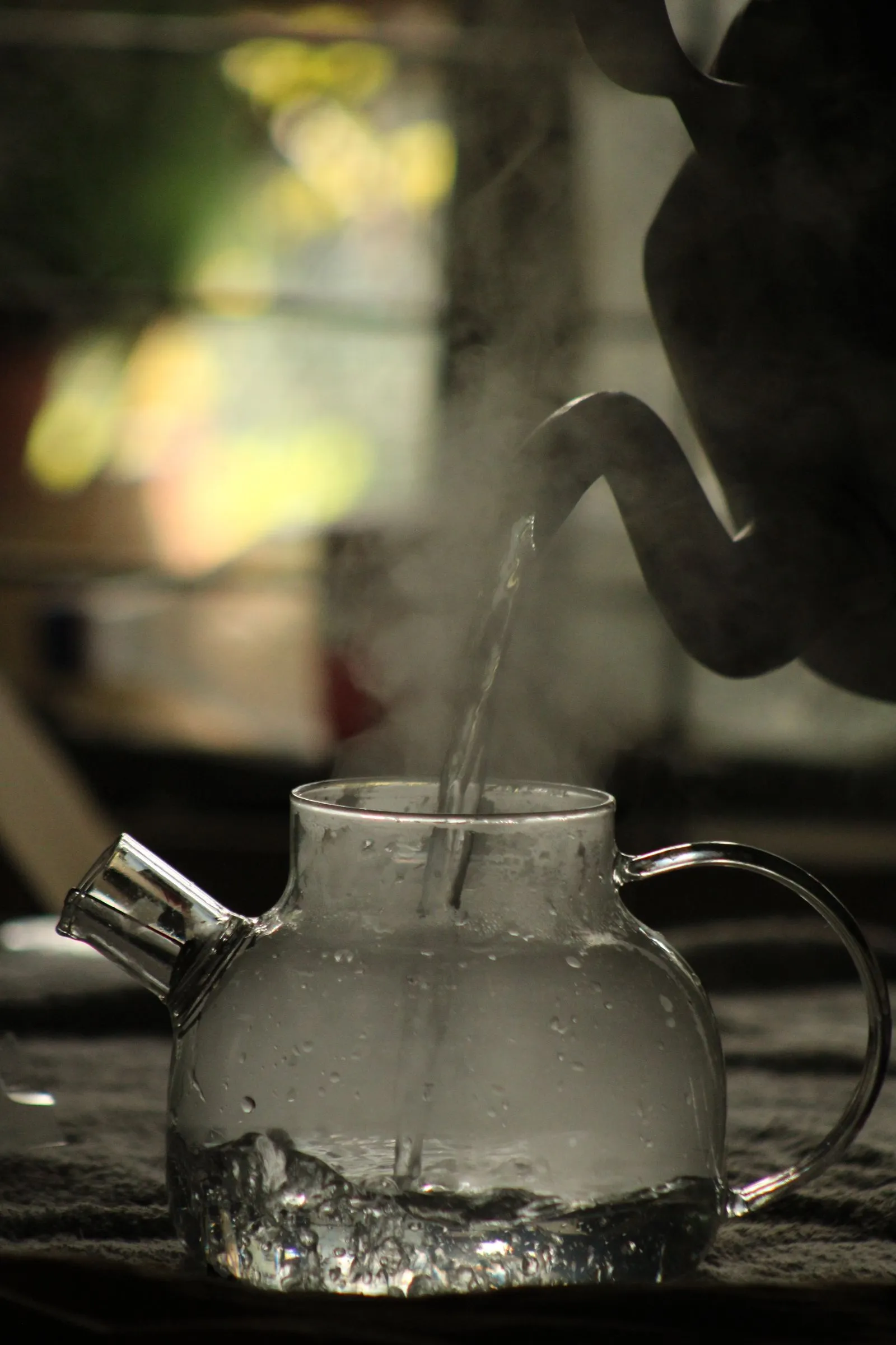 ガラス製の容器に湯気を立てながら湯が注がれている