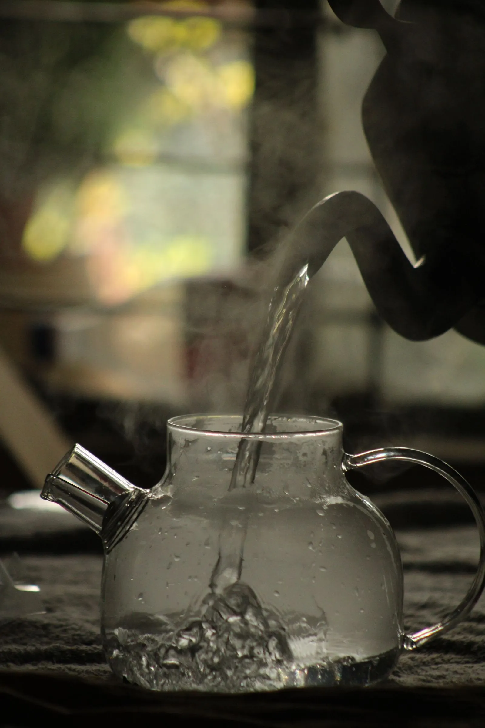 湯気を立てながらガラス製のポットに水が注がれる様子