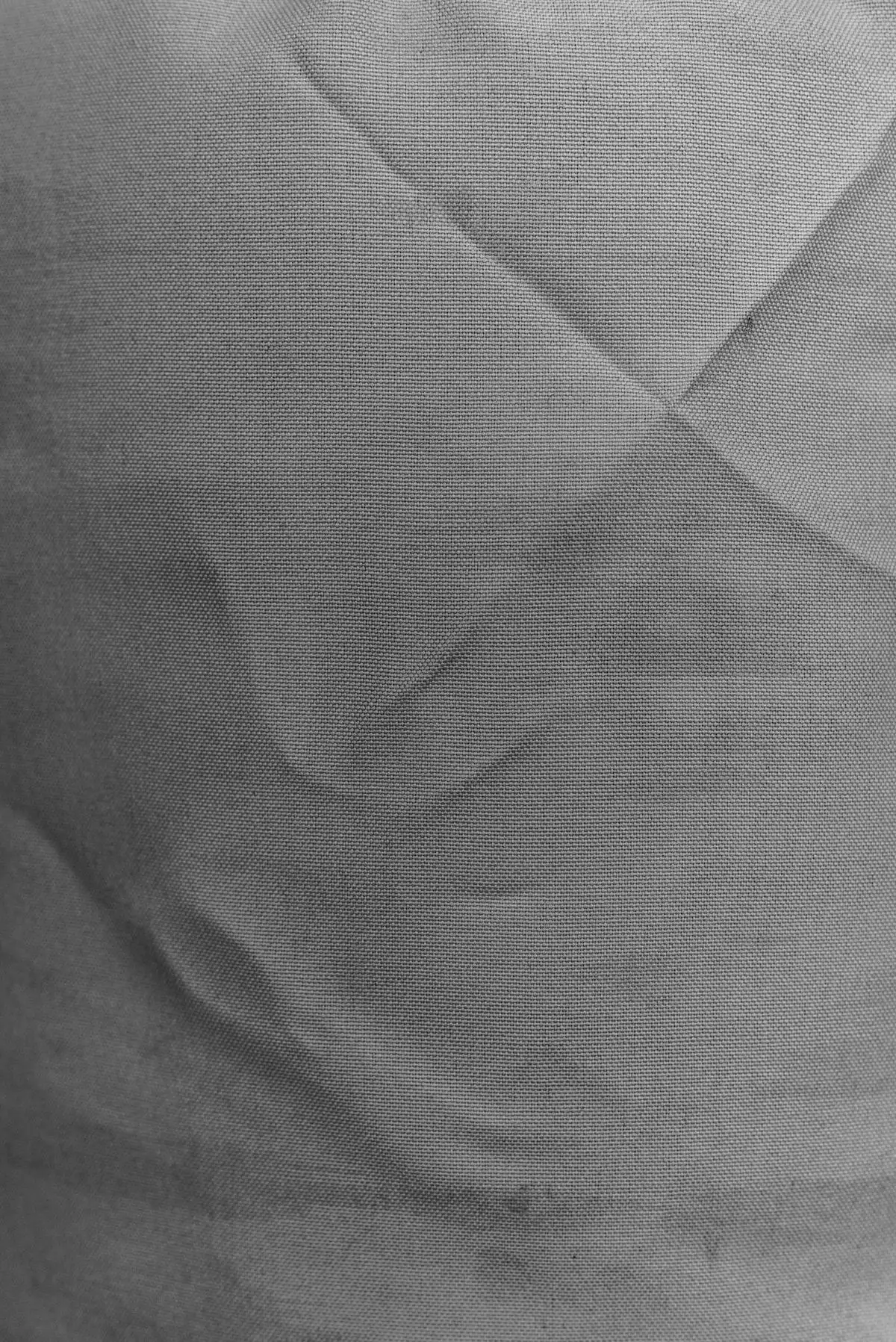 グレーの布地が斜めに折り重なり、織り目の質感が近くから見える