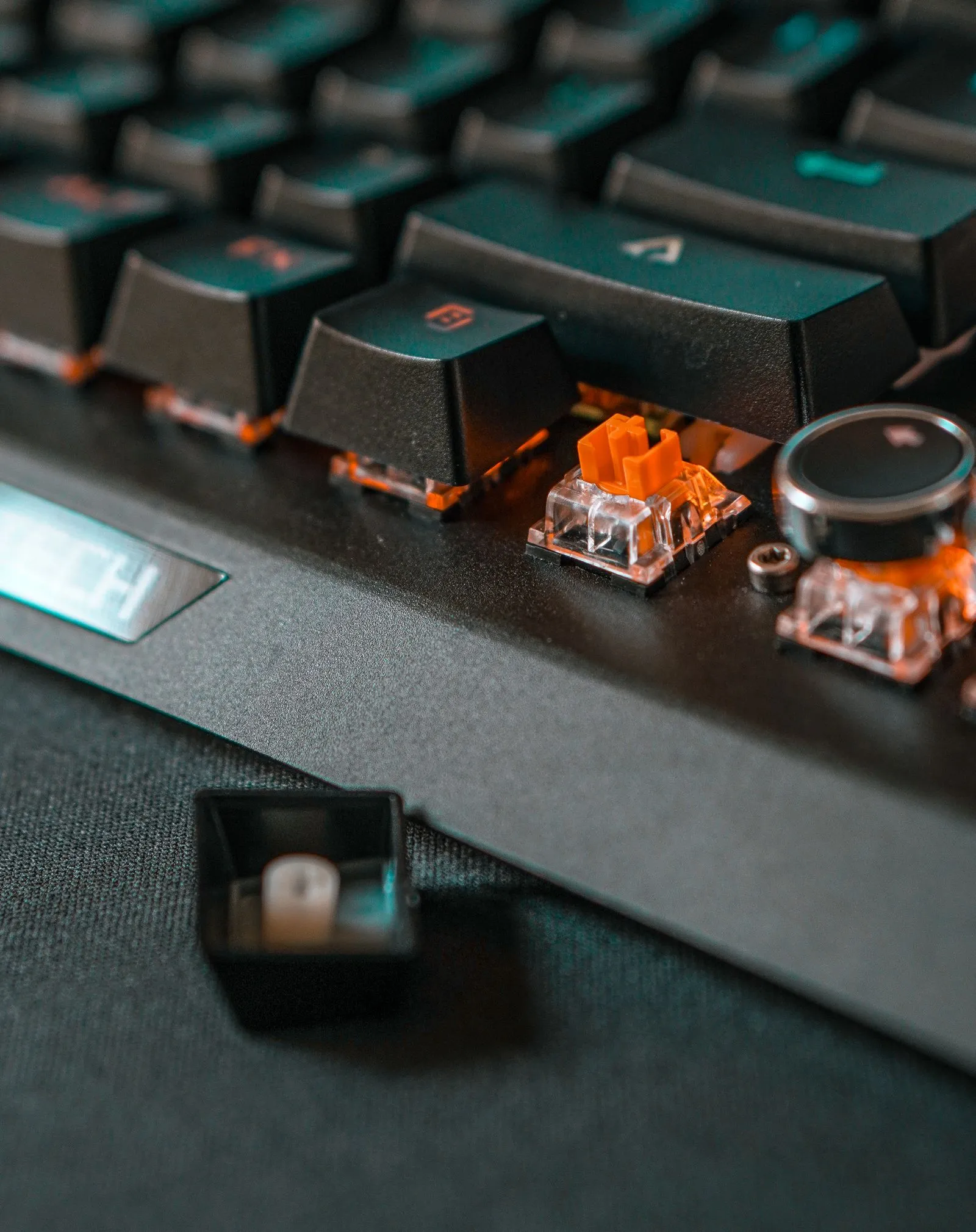 黒いキーボードのキーキャップが外れ、オレンジ色のスイッチと透明なハウジングが露出している