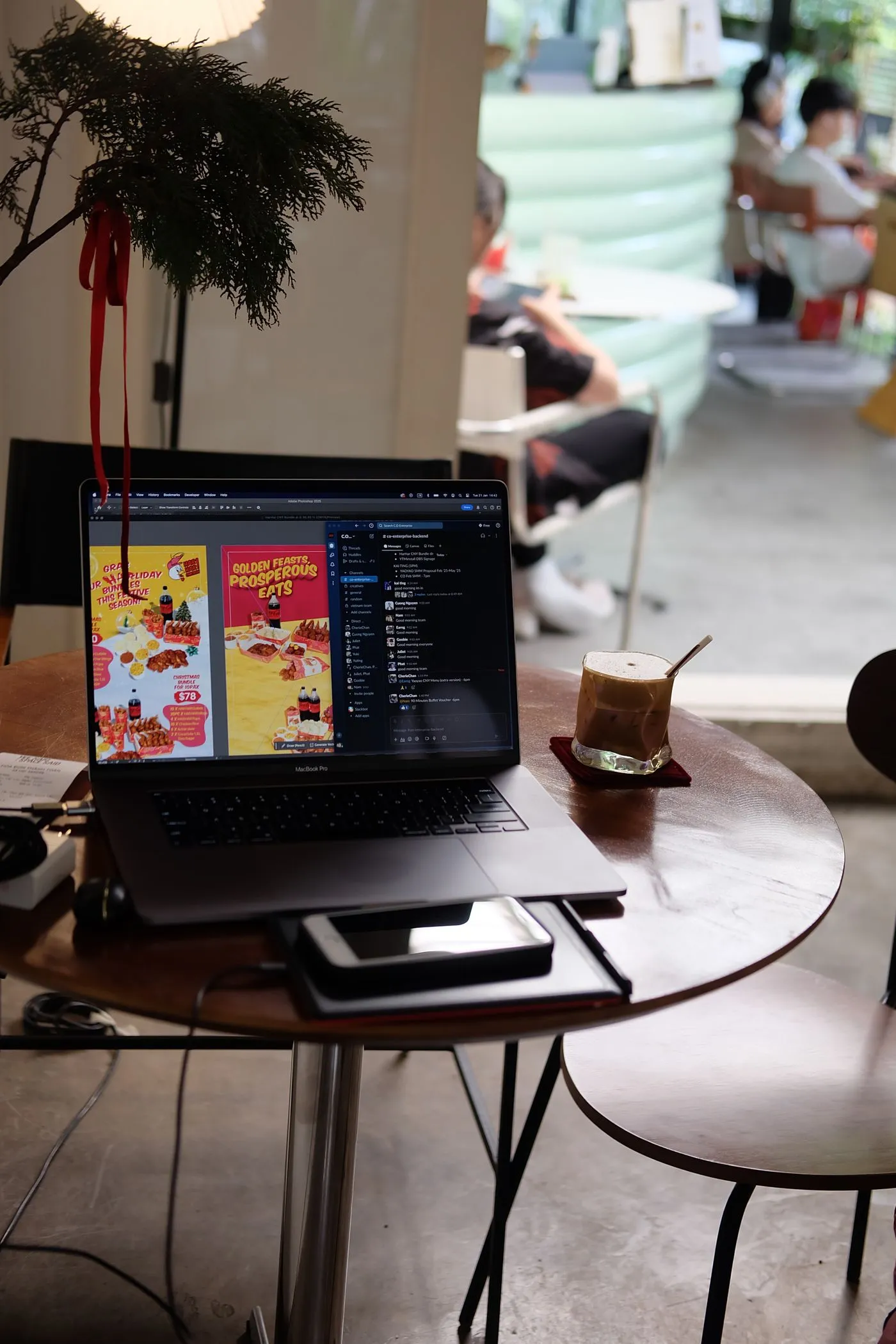 カフェの丸テーブルに広げたノートパソコンと飲み物