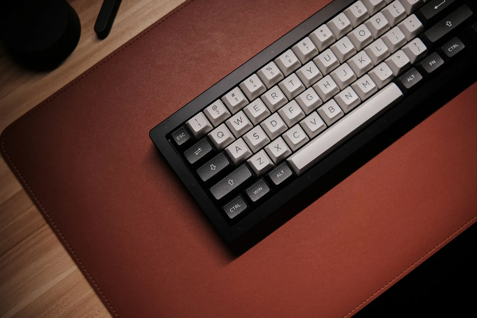 木の机の上、レザーデスクマットに置かれたメカニカルキーボード
