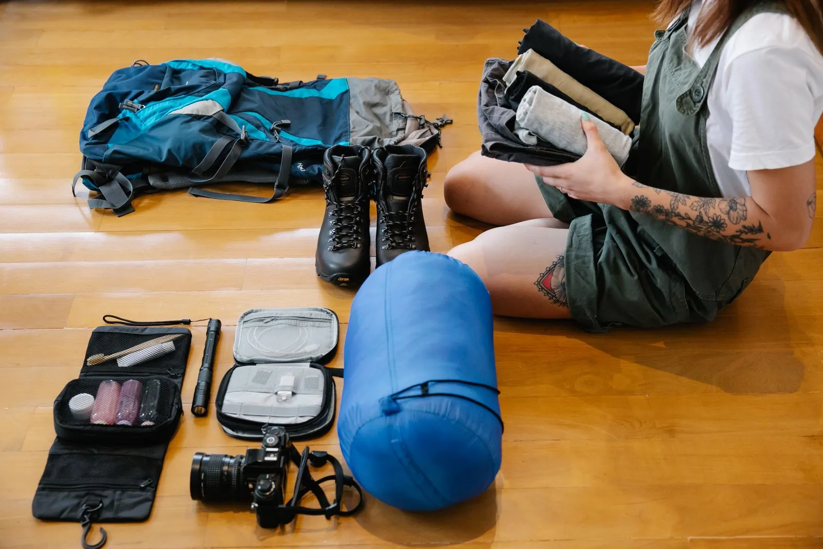 床に置かれた青い収納袋とバックパック、登山靴