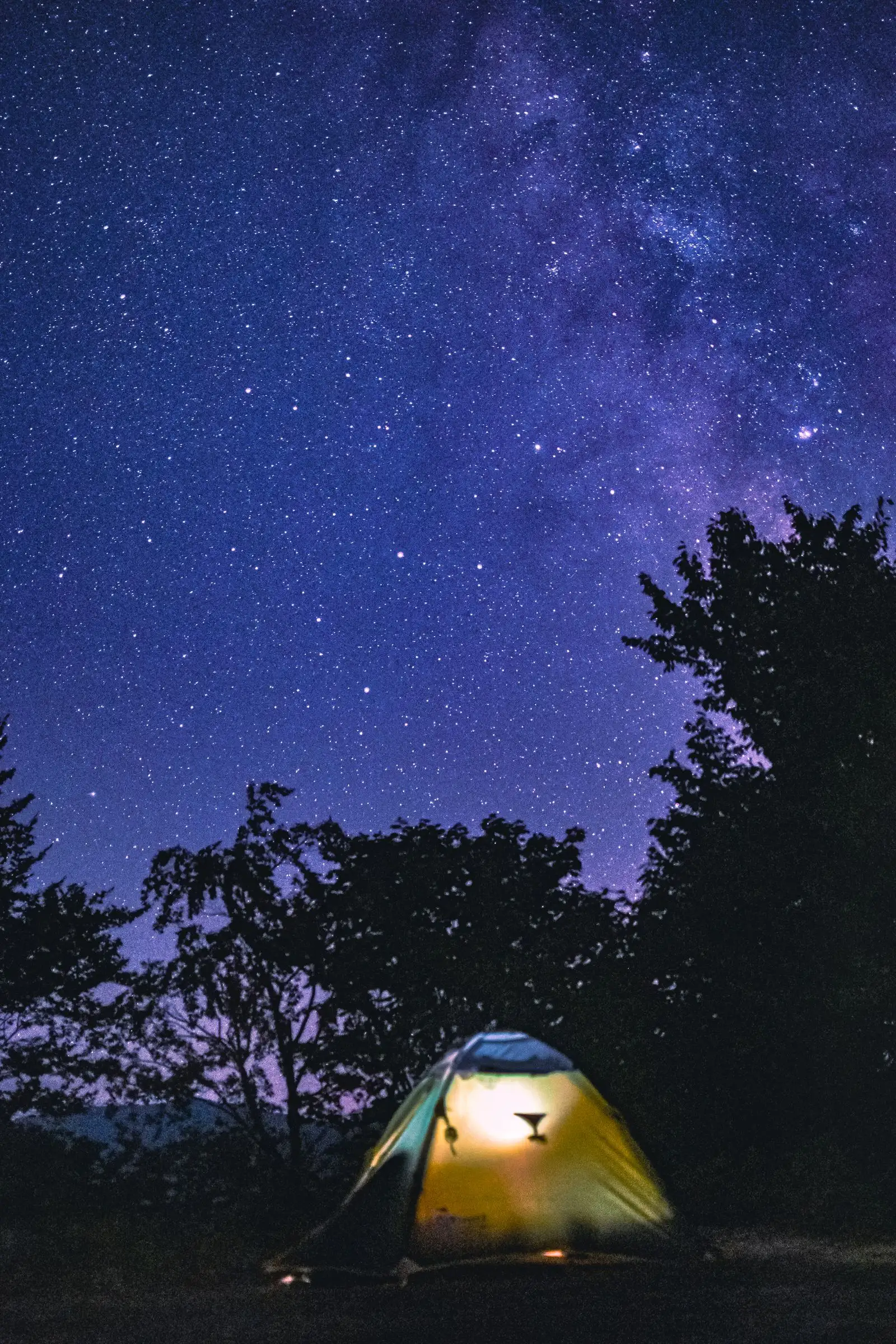満天の星の下で明かりが灯るテント