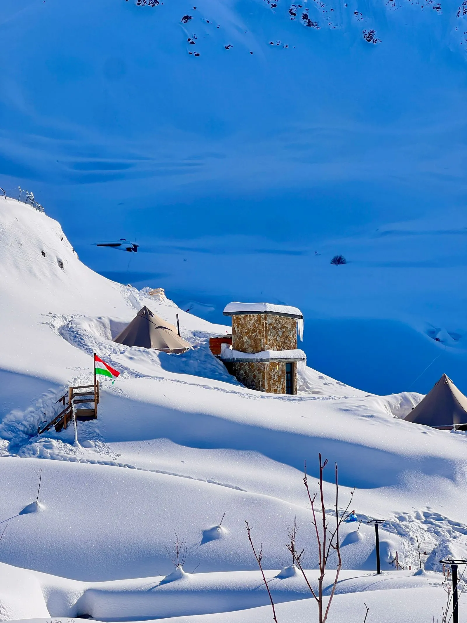 雪に覆われた山の斜面にあるキャンプサイトの遠景