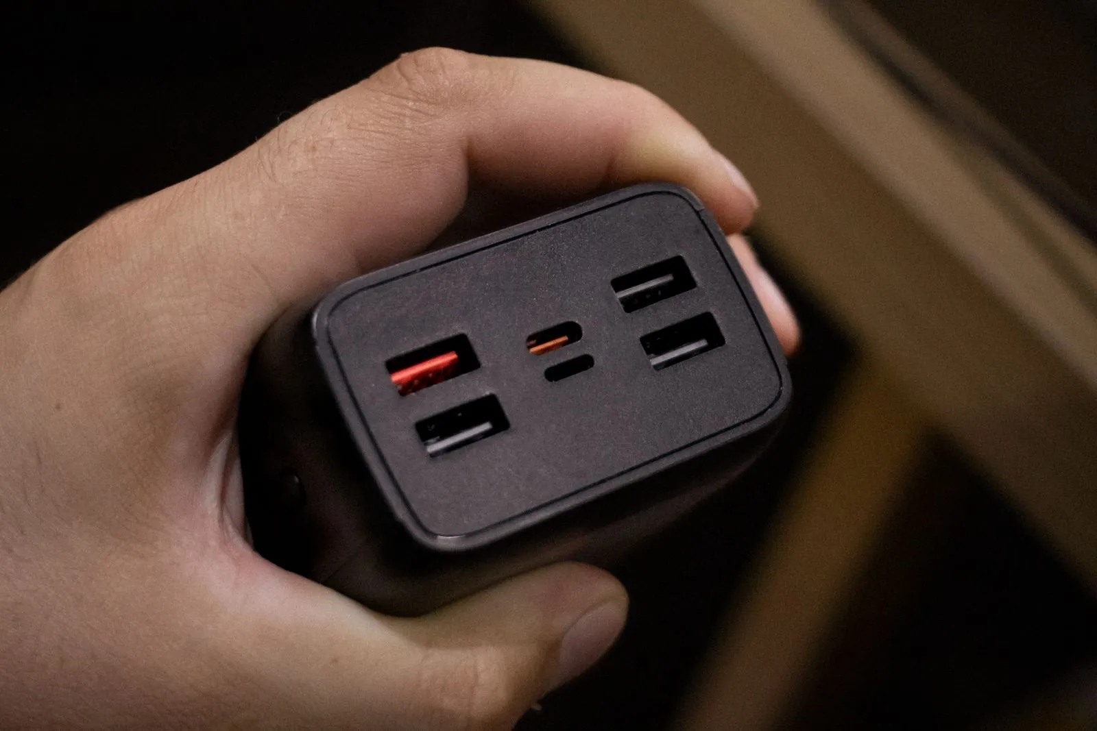 複数のUSBポートがある充電器を持つ手