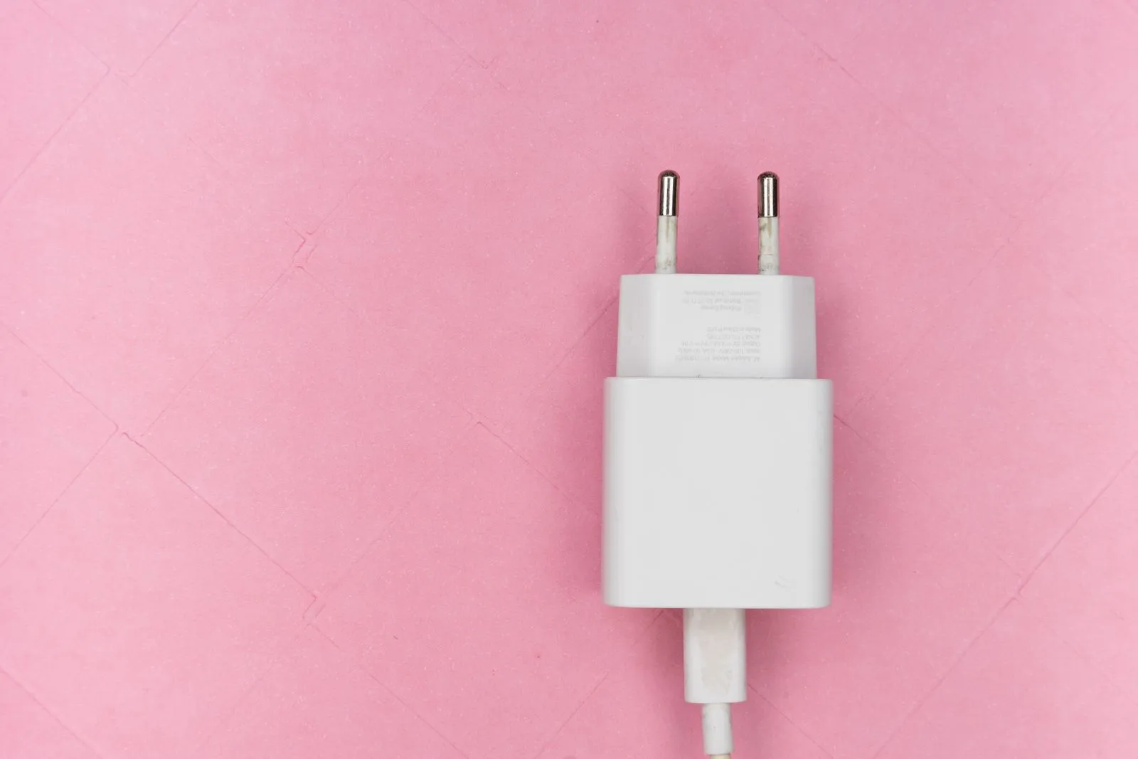 ピンク色の背景に置かれた白い充電器