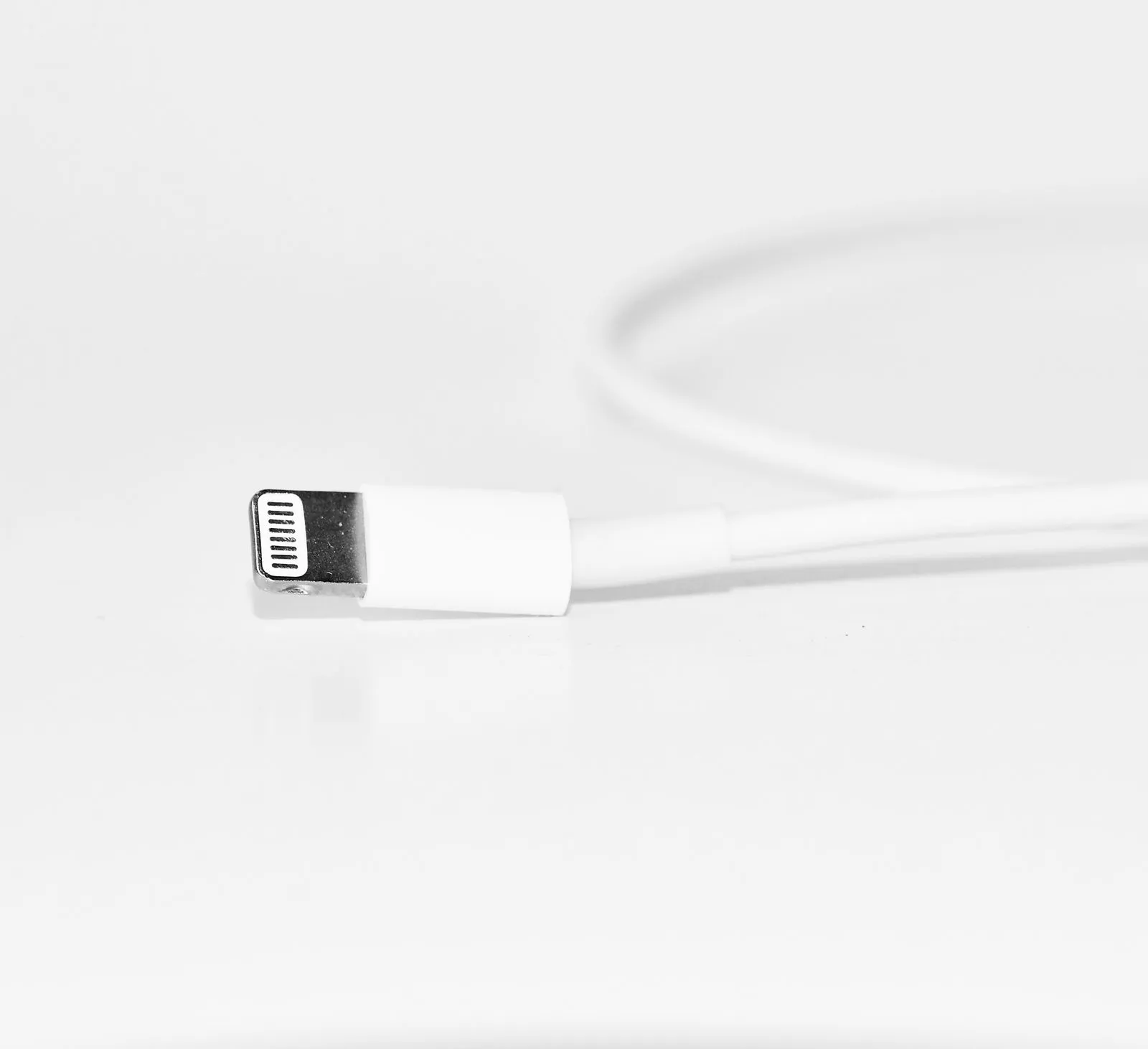 白いテーブルに置かれた白い充電ケーブル